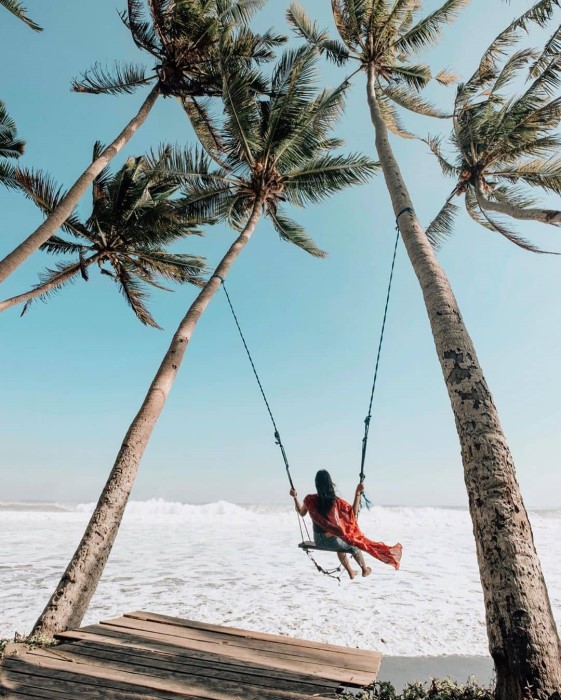 A woman on swing by the beach