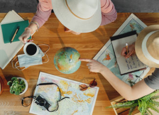 Top,View,Of,Young,Couple,With,Maps,Planning,Vacation,Trip
