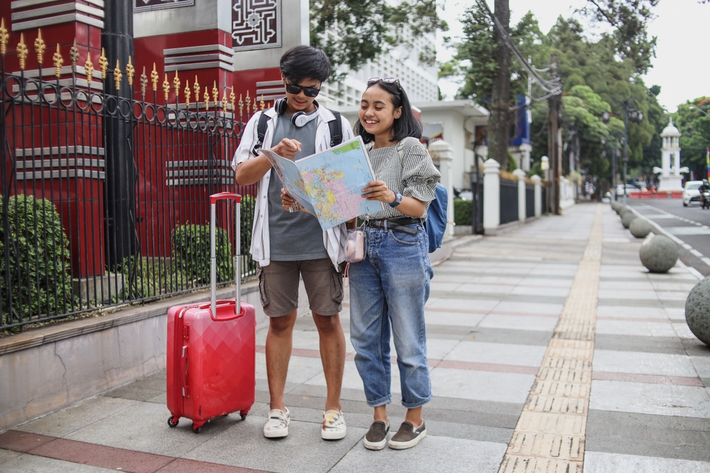 Lost,Young,Asian,Tourists,Couple,Looking,Directions,On,City,Map.