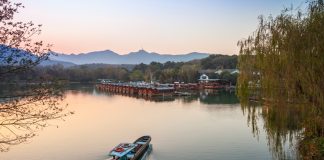 Small,Chinese,Fishing,Boat,With,Boatman,Goes,To,The,West