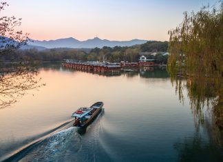 Small,Chinese,Fishing,Boat,With,Boatman,Goes,To,The,West