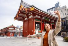 Happy,Asian,Woman,Using,Mobile,Phone,Taking,Selfie,During,Travel