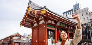 Happy,Asian,Woman,Using,Mobile,Phone,Taking,Selfie,During,Travel