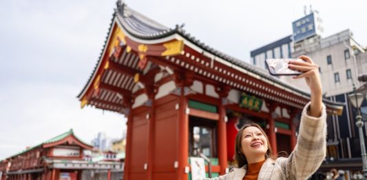 Happy,Asian,Woman,Using,Mobile,Phone,Taking,Selfie,During,Travel